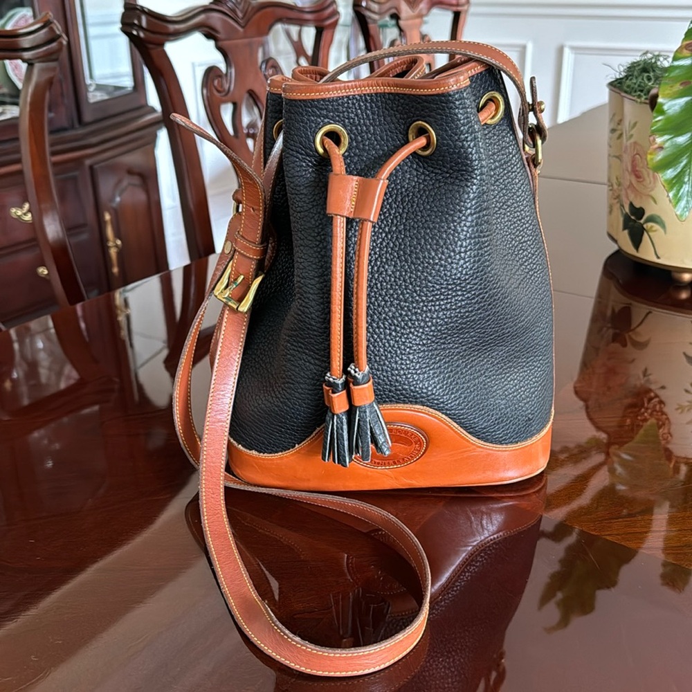 Dooney Burke drawstring all leather handbag in black, with chestnut trim.